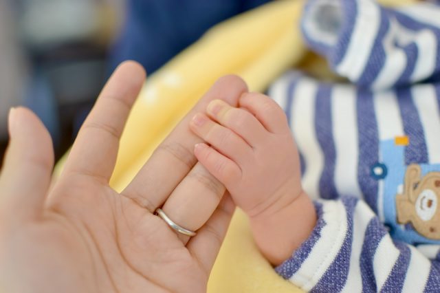 ママの手を握る赤ちゃんの小さな手